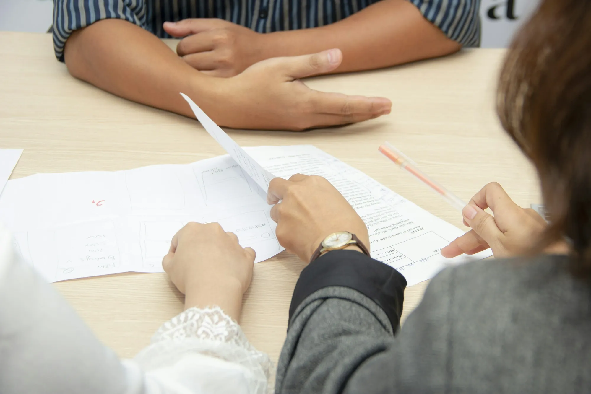 Two people going over papers across a table