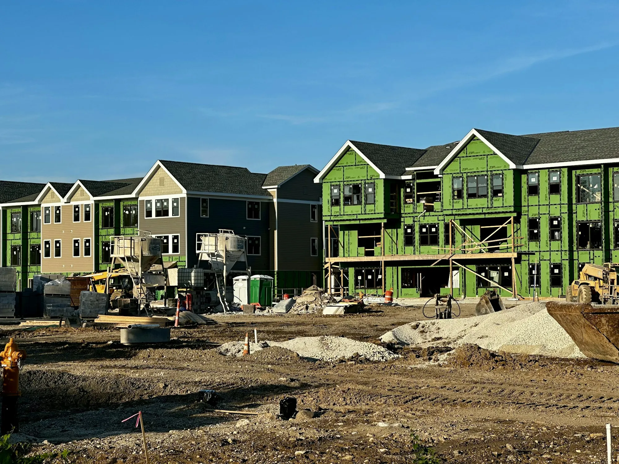 Row of new homes under construction with green sheathing