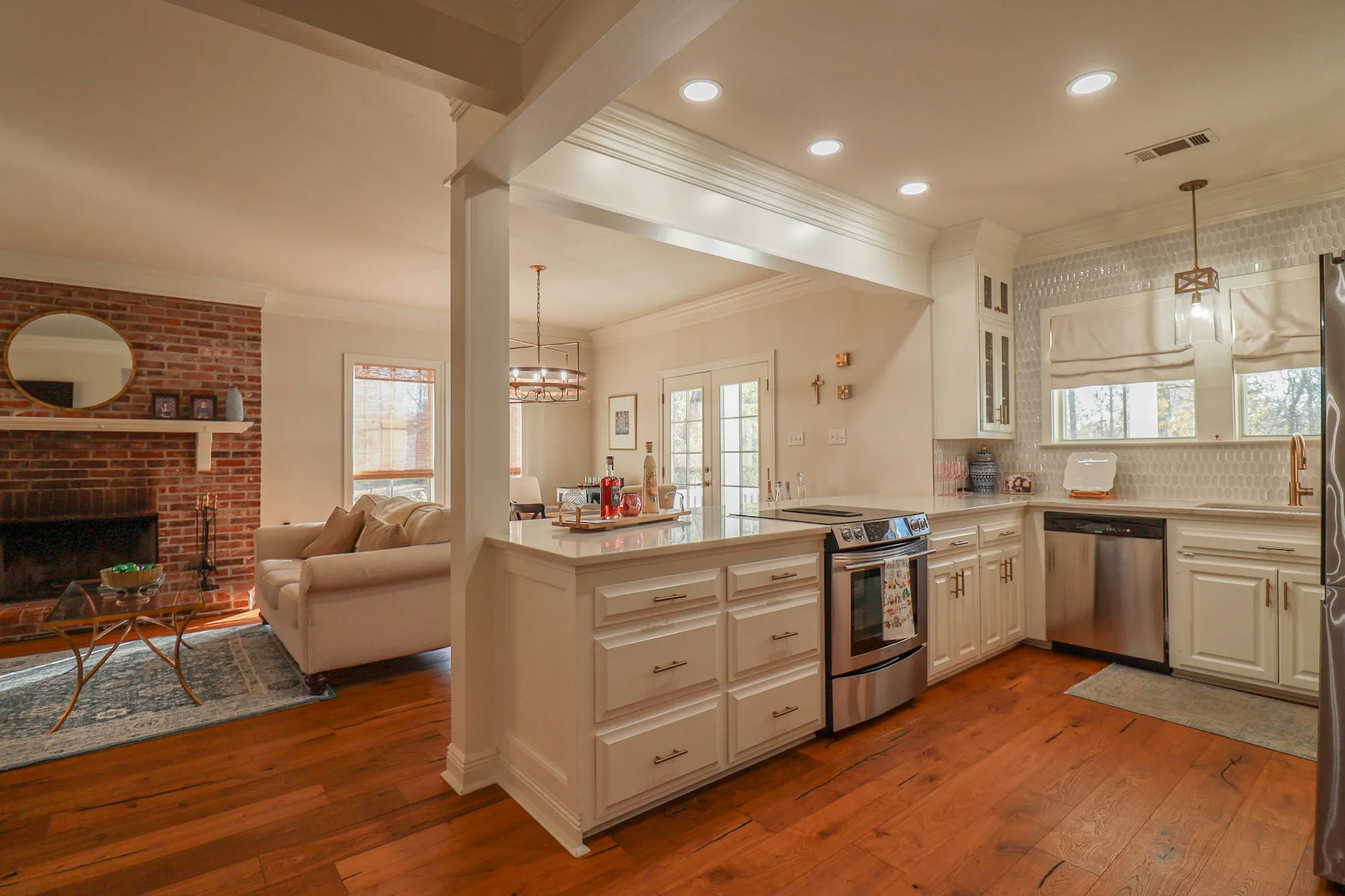 Kitchen open to a living room with a brick fireplace