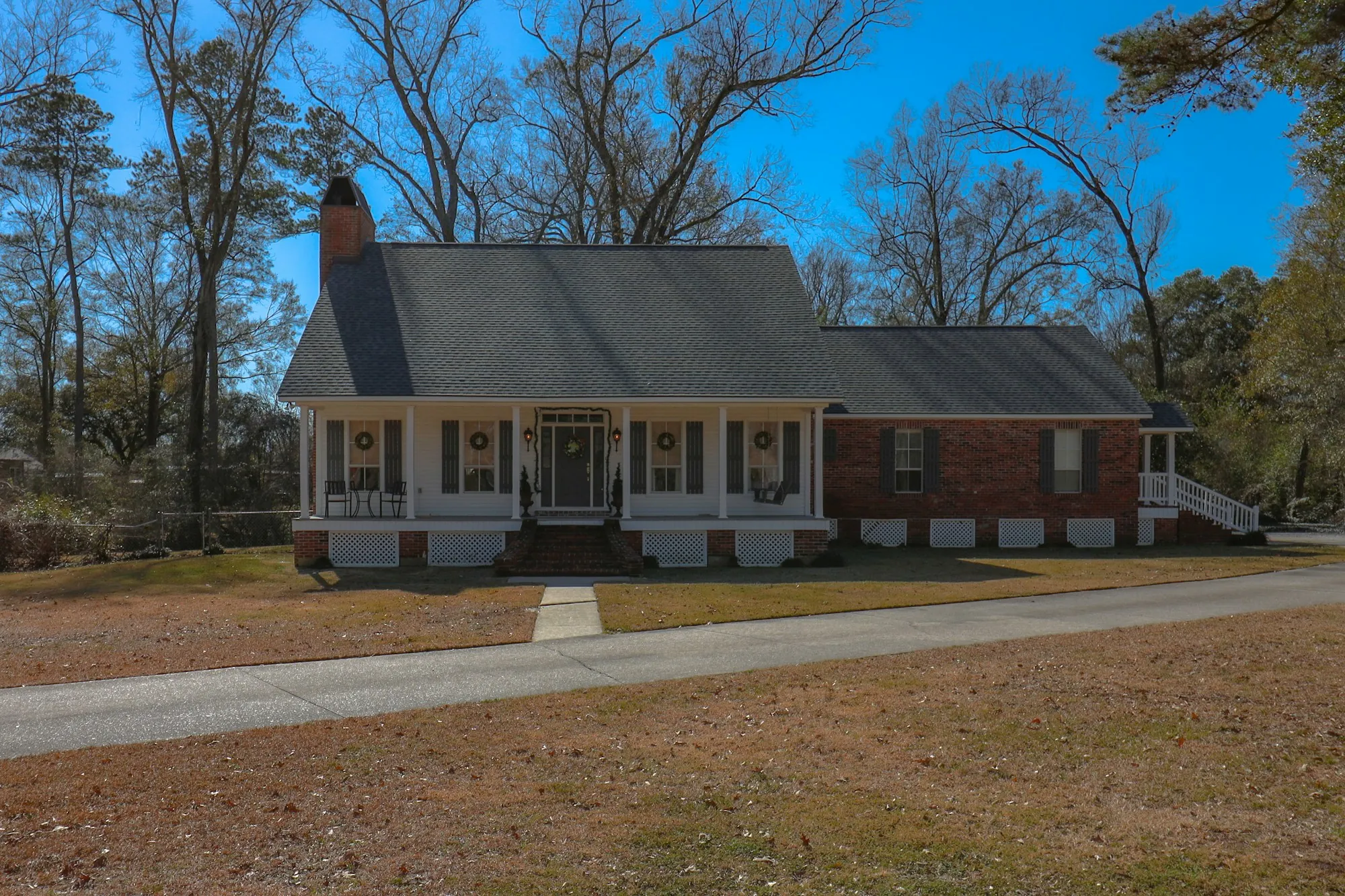 Single-story brick ranch house at the end of a long driveway